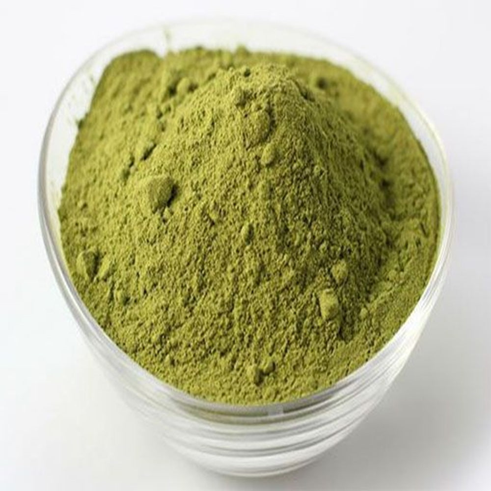 Green Henna in a clear glass bowl on a white background